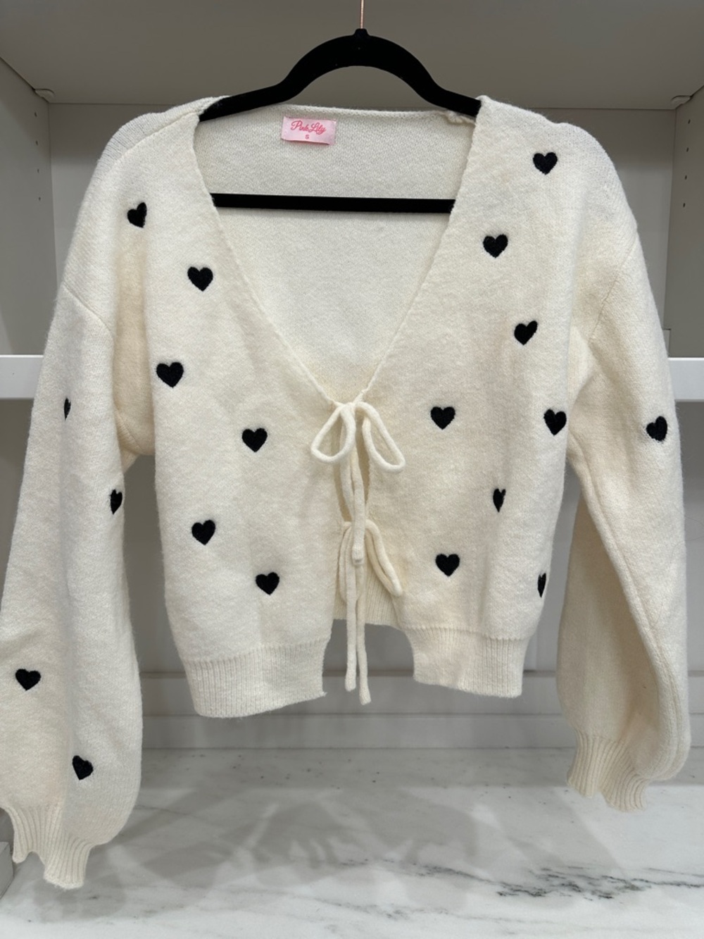 Pink Lily small tie white cardigan with black hearts.  Like new